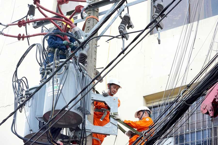 ホーチミン市フートー電力会社の従業員は、人々の日常生活のための電力供給を確保するために中電圧グリッドを維持しています - 写真：HUU HANH