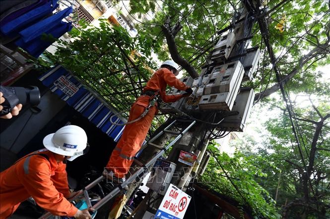 Công nhân Công ty Điện lực Hai Bà Trưng kiểm tra tiếp xúc tại hòm công tơ cấp điện cho hộ dân tại khu vực phường Quỳnh Lôi (Hà Nội).