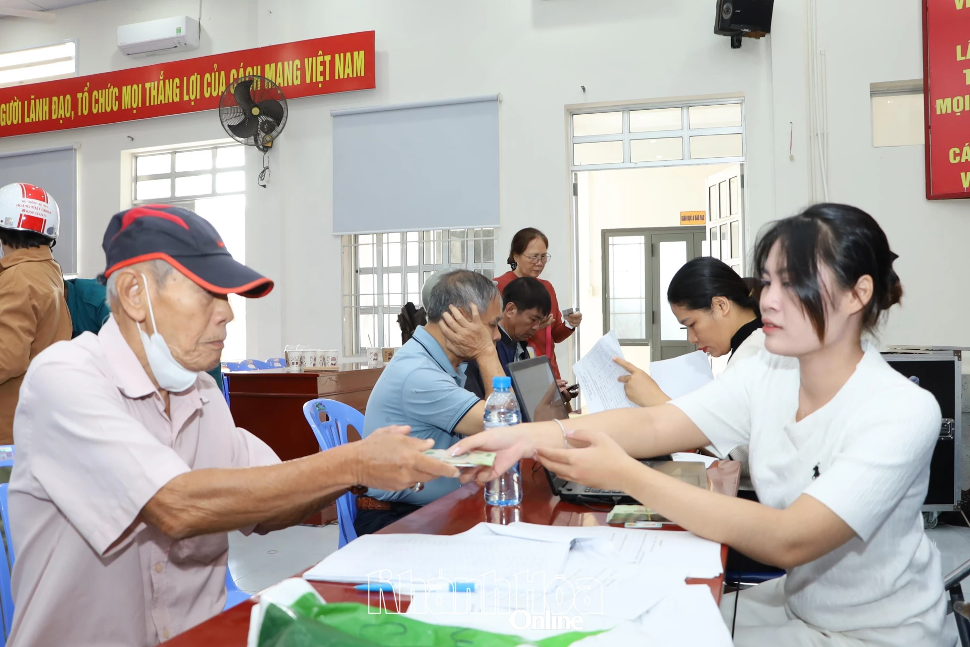 Cán bộ phường Nam Nha Trang trao tiền quà của Đảng, Nhà nước cho người dân.