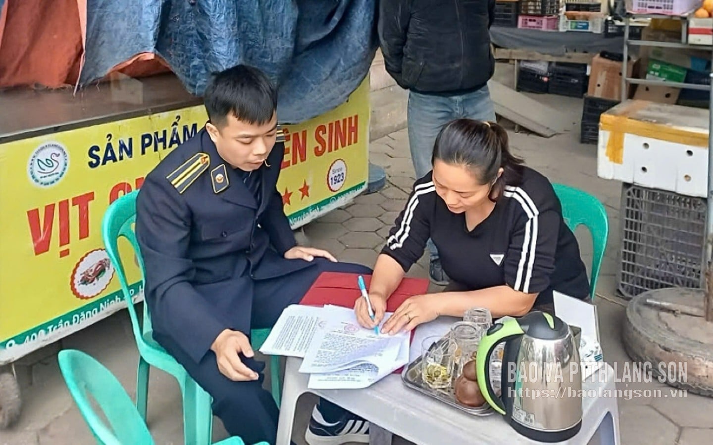 El equipo de cumplimiento del orden urbano del barrio de Dong Kinh solicitó a los propietarios de negocios de la zona que firmaran un compromiso para cumplir con las regulaciones.