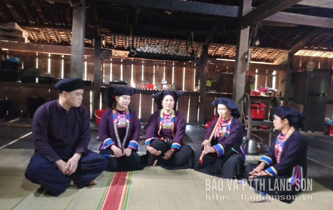 นางสาว Trinh Thi Nhinh และ Ms. Trinh Thi Khen (ที่สองและสามจากขวา) ในกลุ่มร้องเพลง Tu Si Na Mieo ในเมือง Khuoi Lam