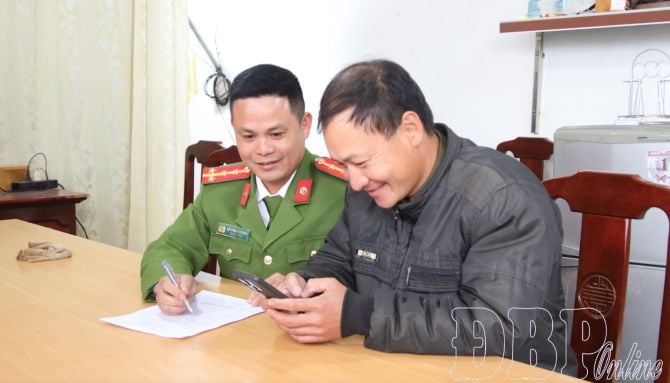 Cảnh sát khu vực hướng dẫn ông Lò Văn Thướng, bản Noong Hẹt, xã Thanh An thực hiện dịch vụ công trực tuyến. Ảnh: Báo, Phát thanh và Truyền hình tỉnh Điện Biên.