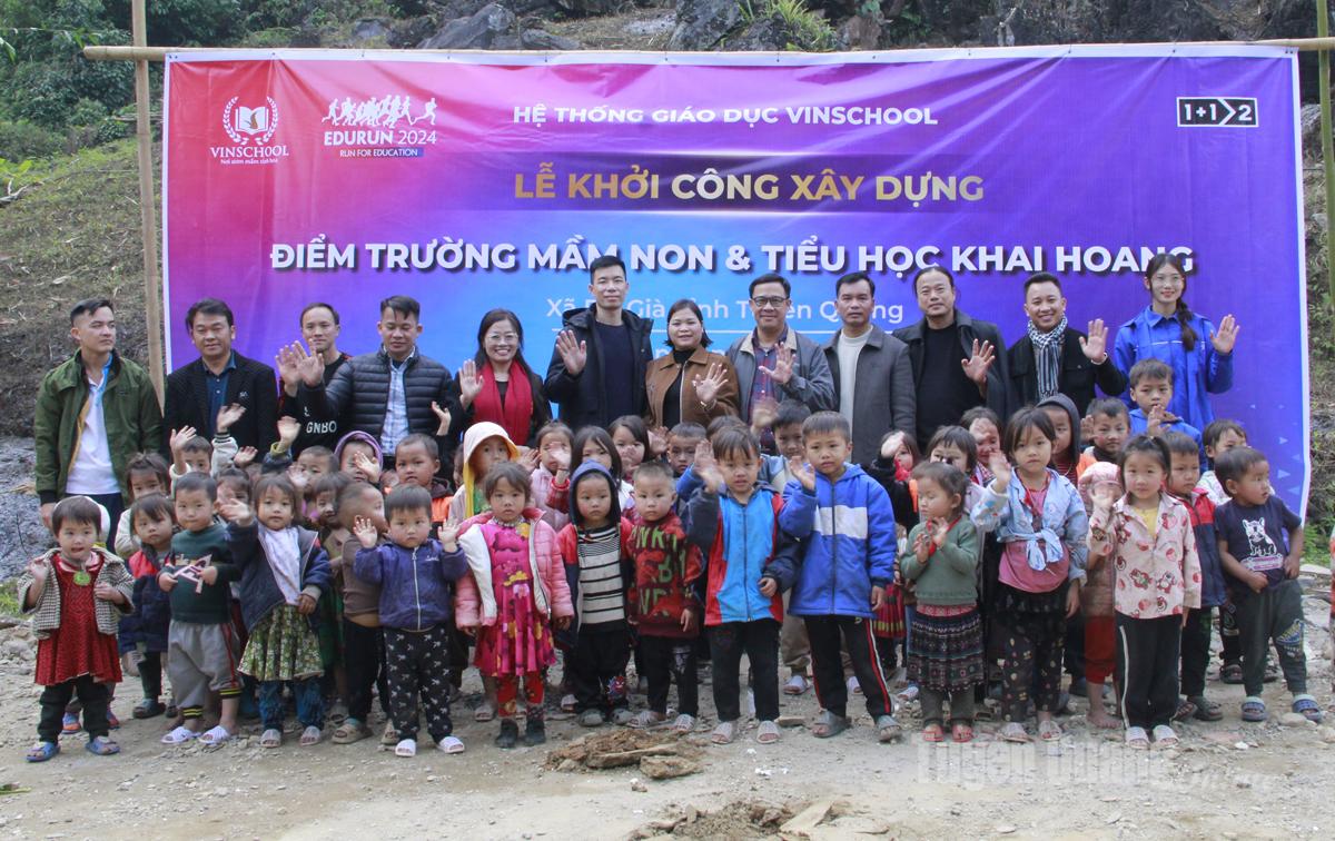 Patrocinadores y autoridades locales posan para una foto con profesores y estudiantes en la escuela Khai Hoang.