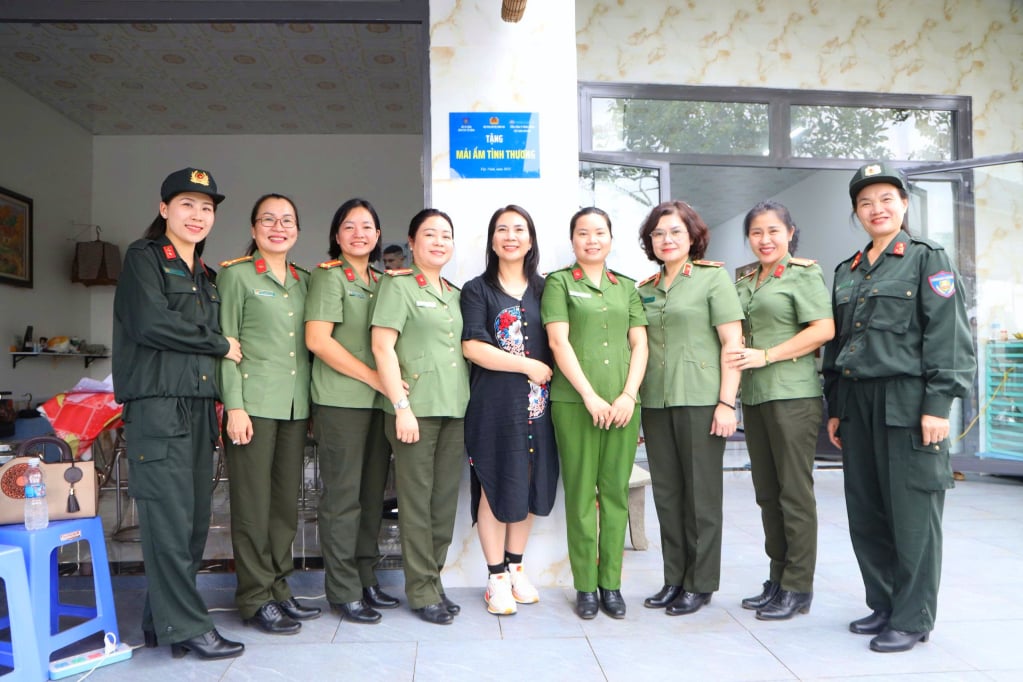 I delegati posano per una foto con la famiglia del Capitano Phan Thị Thanh Mai davanti alla loro nuova casa.