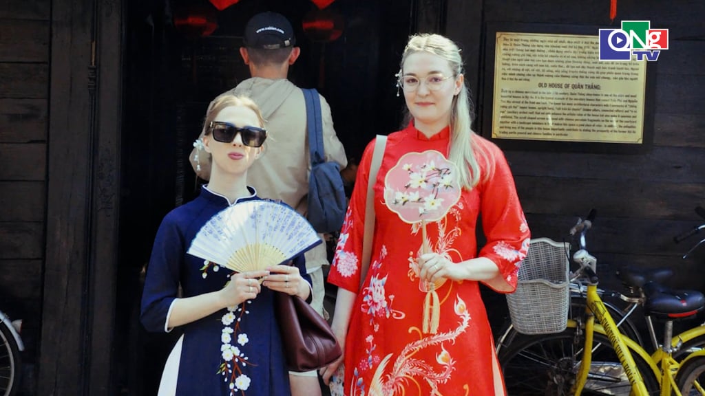 A foreign couple, dressed in dark blue ao dai (traditional Vietnamese dress), radiated beauty amidst the dazzling atmosphere of Hoi An, the 