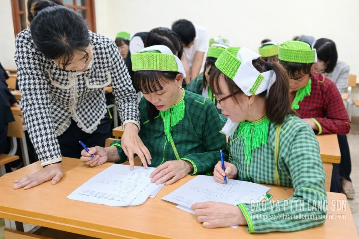 Giáo viên hướng dẫn học viên đọc, viết tại lớp xóa mù chữ xã Ba Sơn