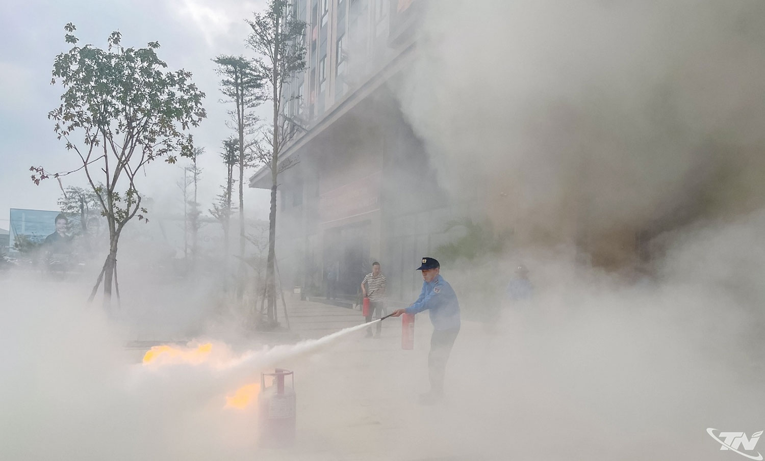 De lokale brandweer en reddingsdiensten oefenen met het gebruik van poederblussers.