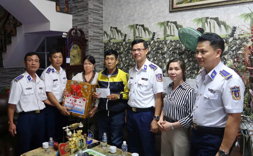 Il colonnello Cao Xuan Quan, vice commissario politico della terza regione della Guardia Costiera, consegna dei doni alle famiglie beneficiarie delle politiche e ai pescatori in difficoltà nella zona economica speciale di Phu Quy.