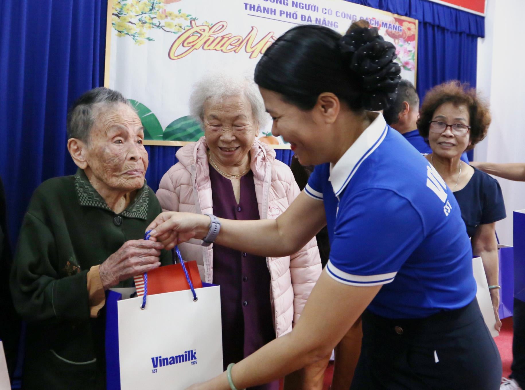 La signora Tran Thi My Binh, direttrice della filiale Vinamilk di Da Nang, distribuisce doni per il Tet agli anziani del Centro per l'assistenza ai veterani della rivoluzione nella città di Da Nang. Foto: HAU - HUNG