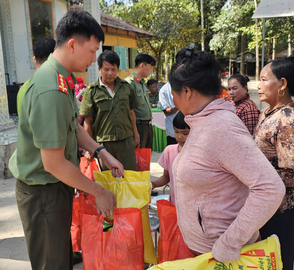 Captain Van Cong Chien - Secretary of the Youth Union of the Internal Security and Immigration Management Department, Tay Ninh Provincial Police (far left) presents gifts to the people.