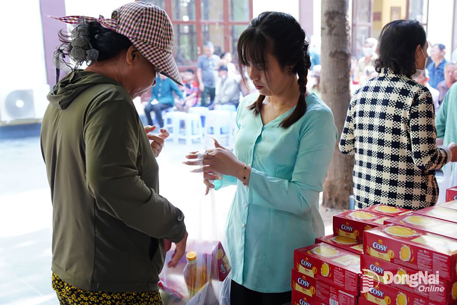 Đại diện các mạnh thường quân và tình nguyện viên hỗ trợ trao quà cho người dân phường Trấn Biên. Ảnh: Lê Duy