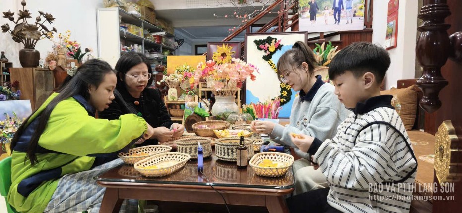 អ្នកស្រី ទ្រឿង ក្វឺឡាន ណែនាំសិស្សានុសិស្សក្នុងការធ្វើផ្កាឈូកពីសំបកពោត។