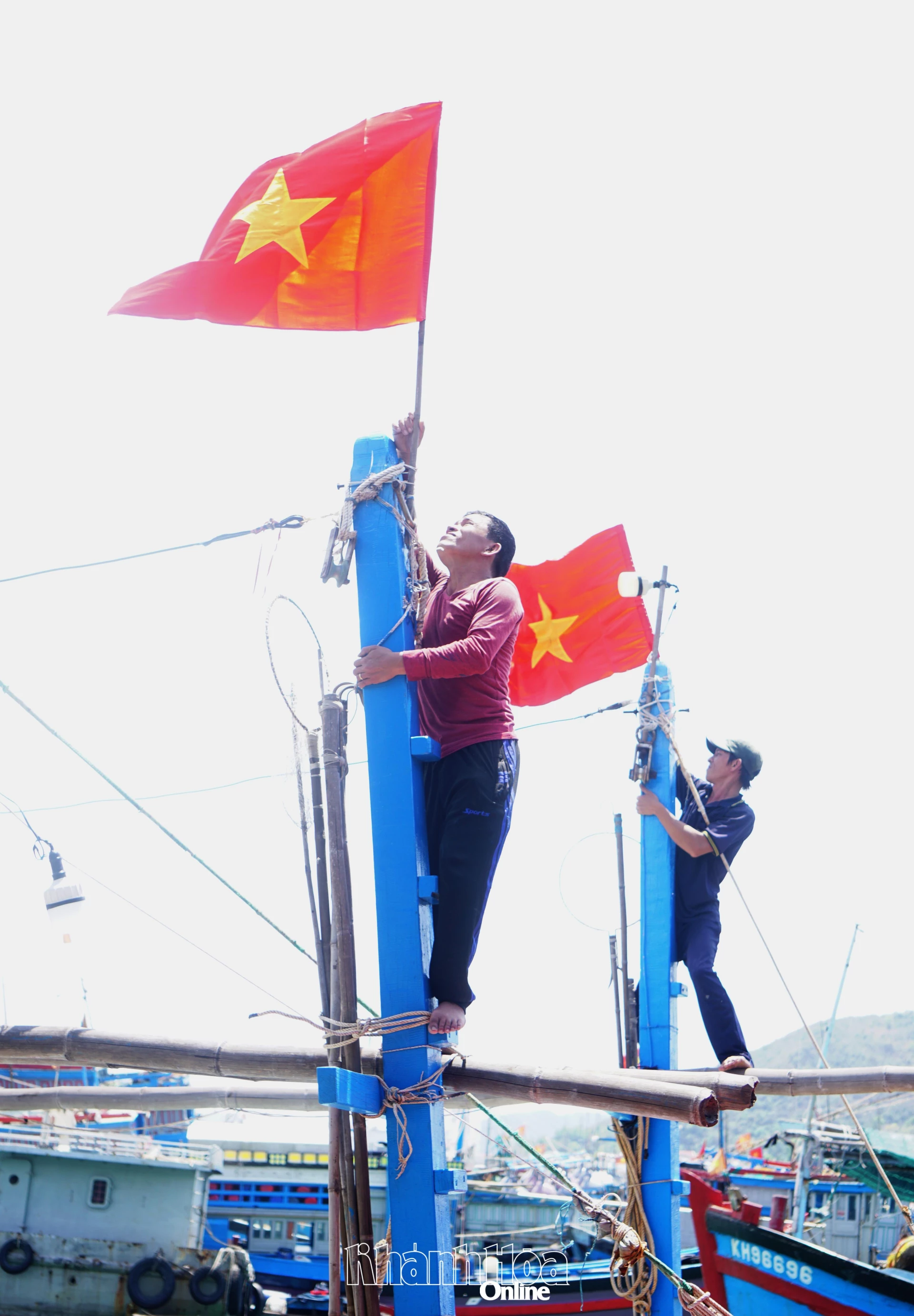 Ngư dân thay mới cờ Tổ quốc trước chuyến vươn khơi.