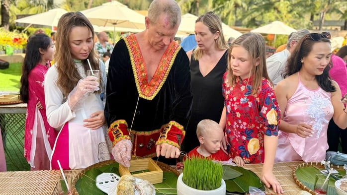 Internationale Touristen erleben das vietnamesische Tet (Mondneujahr) und stellen Banh Chung (traditionelle Reiskuchen) in Mui Ne her - Foto 2. Du khách quốc tế trải nghiệm Tết Việt, gói bánh chưng tại Mũi Né - Ảnh 2.