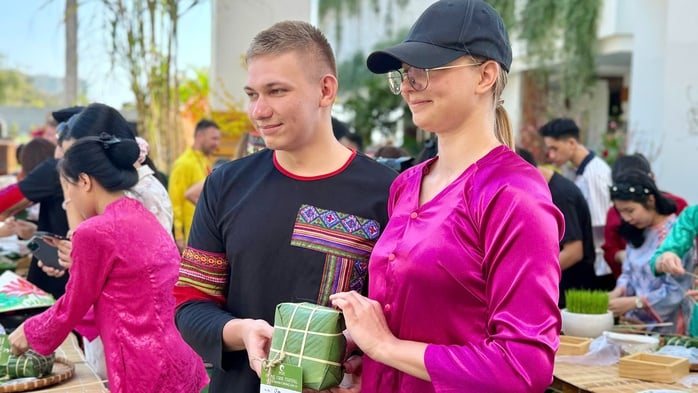 Internationale Touristen erleben das vietnamesische Tet (Mondneujahr) und stellen Banh Chung (traditionelle Reiskuchen) in Mui Ne her - Foto 3. Du khách quốc tế trải nghiệm Tết Việt, gói bánh chưng tại Mũi Né - Ảnh 3.