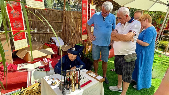 Internationale Touristen erleben das vietnamesische Tet (Mondneujahr) und stellen Banh Chung (traditionelle Reiskuchen) in Mui Ne her - Foto 6. Du khách quốc tế trải nghiệm Tết Việt, gói bánh chưng tại Mũi Né - Ảnh 6.