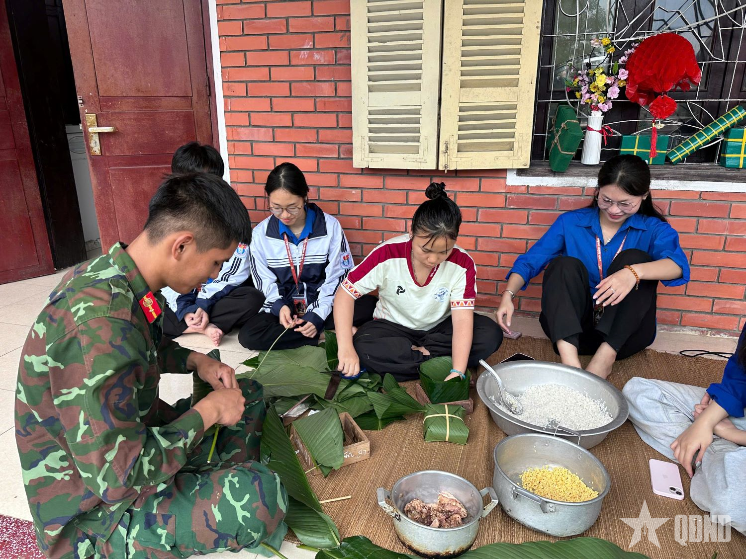 Bộ đội và các em trong Làng trẻ em SOS Vinh gói bánh chưng.