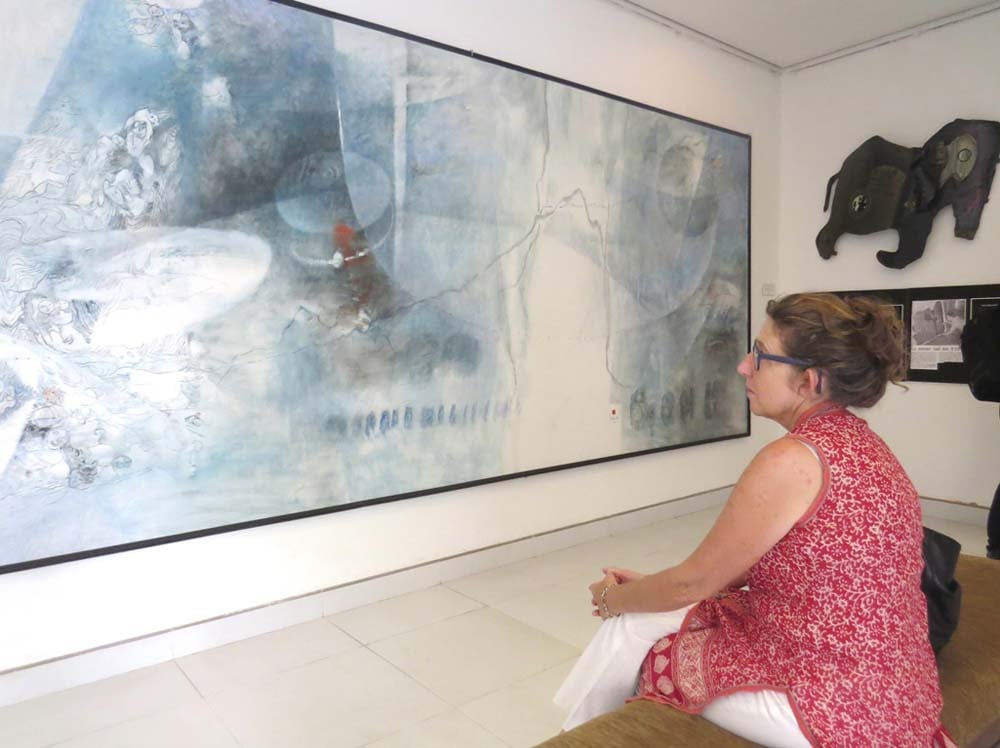 Un visitatore osserva i dipinti dell'artista Le Ba Dang presso il Centro d'Arte Le Ba Dang (Hue).