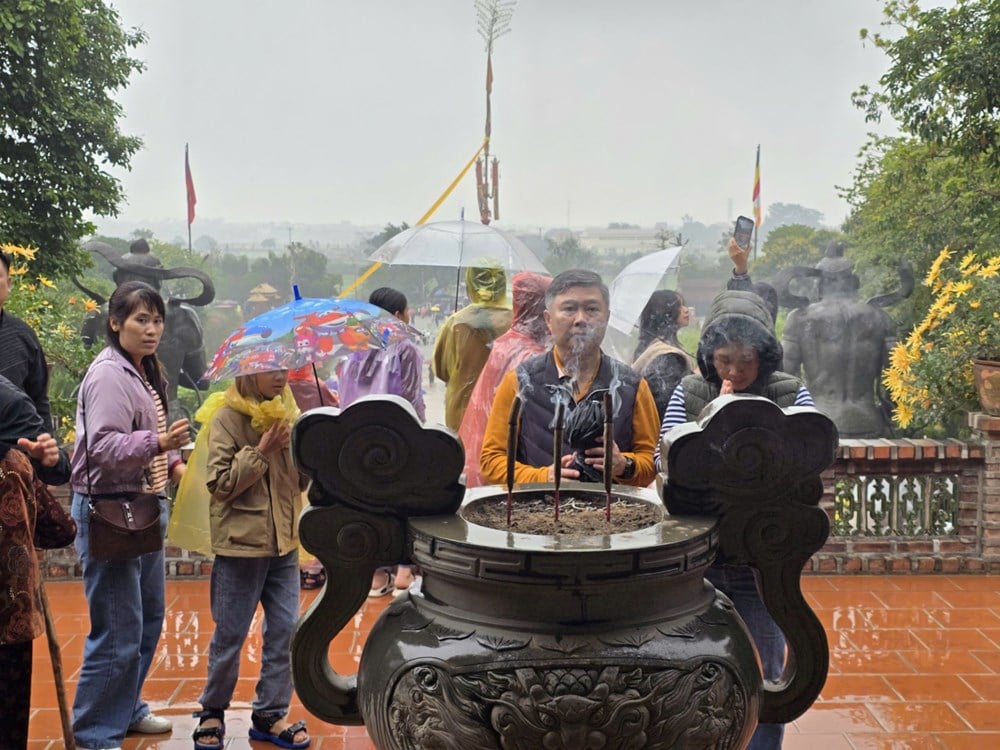 I visitatori sfidano la pioggia primaverile per ammirare il paesaggio presso la pagoda Dia Tang Phi Lai - foto 6