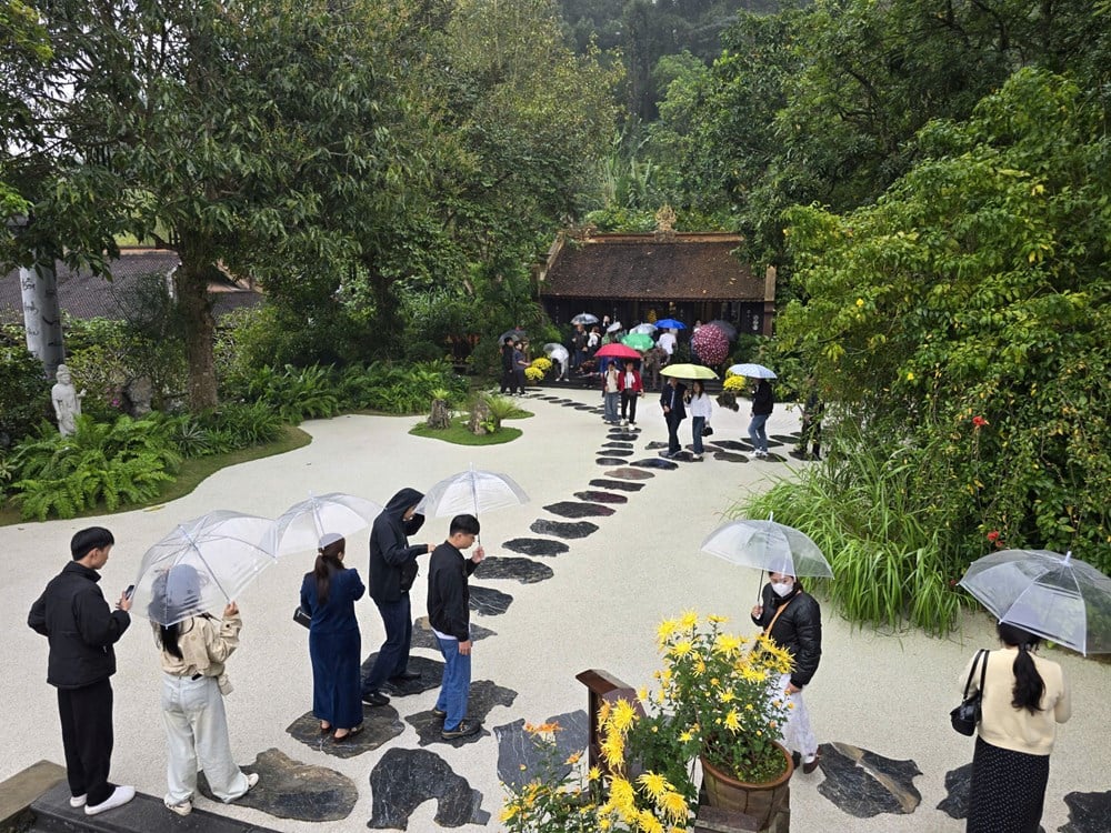 I visitatori sfidano la pioggia primaverile per ammirare il paesaggio presso la pagoda Dia Tang Phi Lai - foto 13