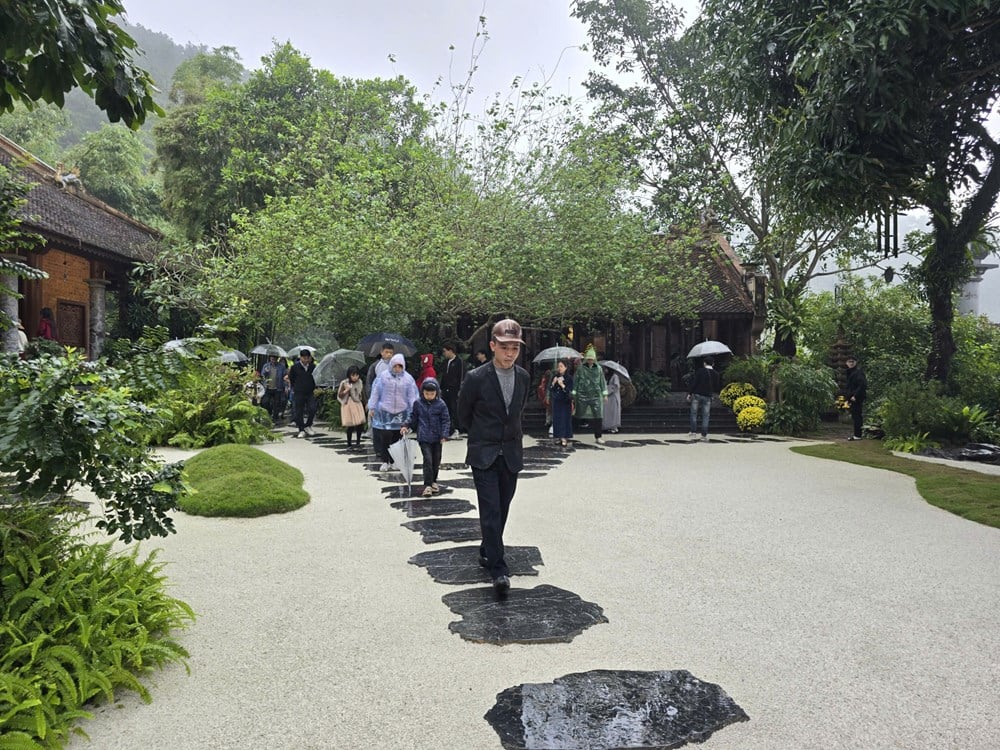 I visitatori sfidano la pioggia primaverile per ammirare il paesaggio presso la pagoda Dia Tang Phi Lai - foto 15
