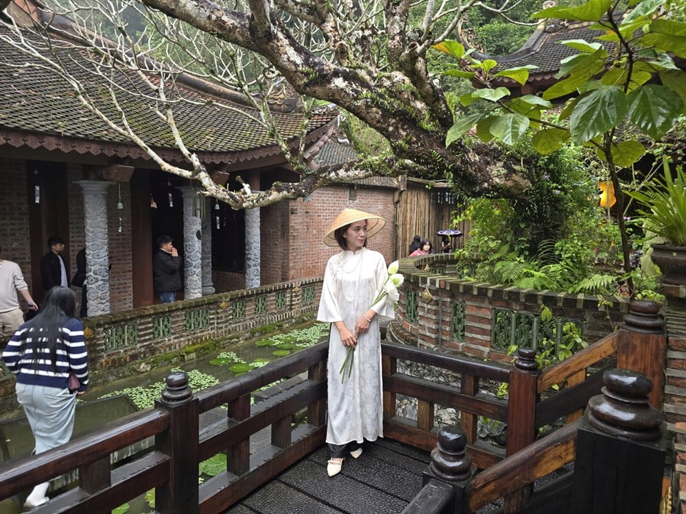I visitatori sfidano la pioggia primaverile per ammirare il paesaggio presso la pagoda Dia Tang Phi Lai - foto 18