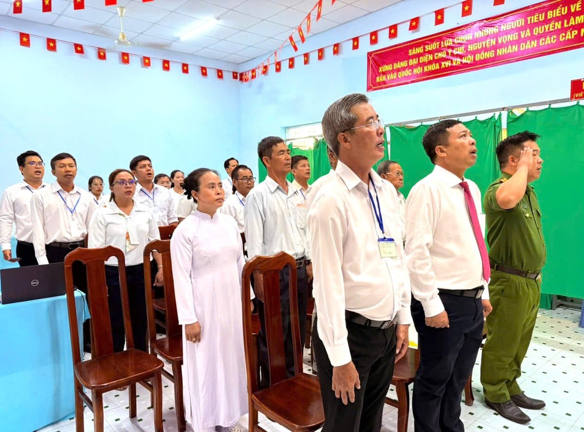 Tổ bầu cửa và cử tri chào cờ vào lúc 6 giờ 30 tại điểm bỏ phiếu số 4, ấp đảo Thiềng Liềng, xã Thạnh An, TP. HCM
