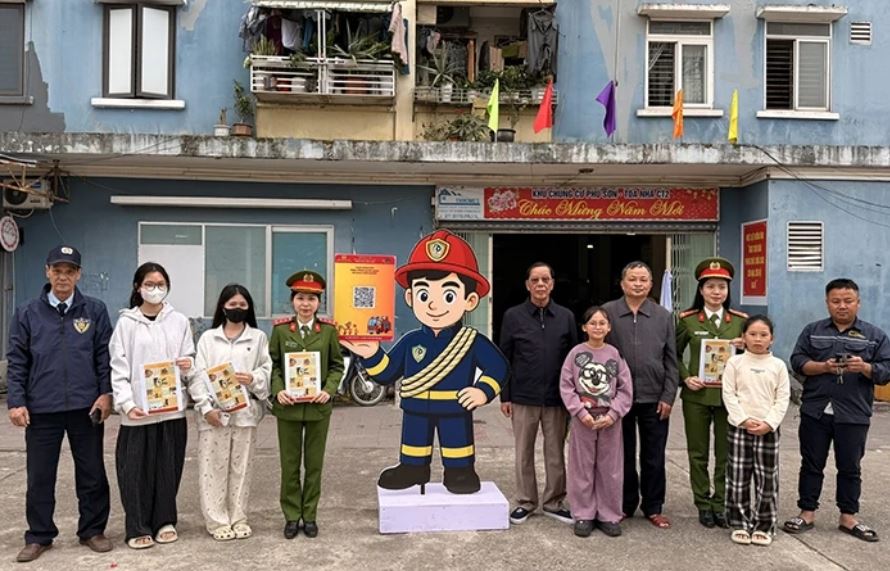 Cán bộ Phòng Cảnh sát PCCC&CNCH hướng dẫn người dân tại chung cư Phú Sơn, phường Hạc Thành quét mã QR để tìm hiểu kiến thức, kỹ năng an toàn về PCCC. Ảnh: Báo Thanh Hóa.
