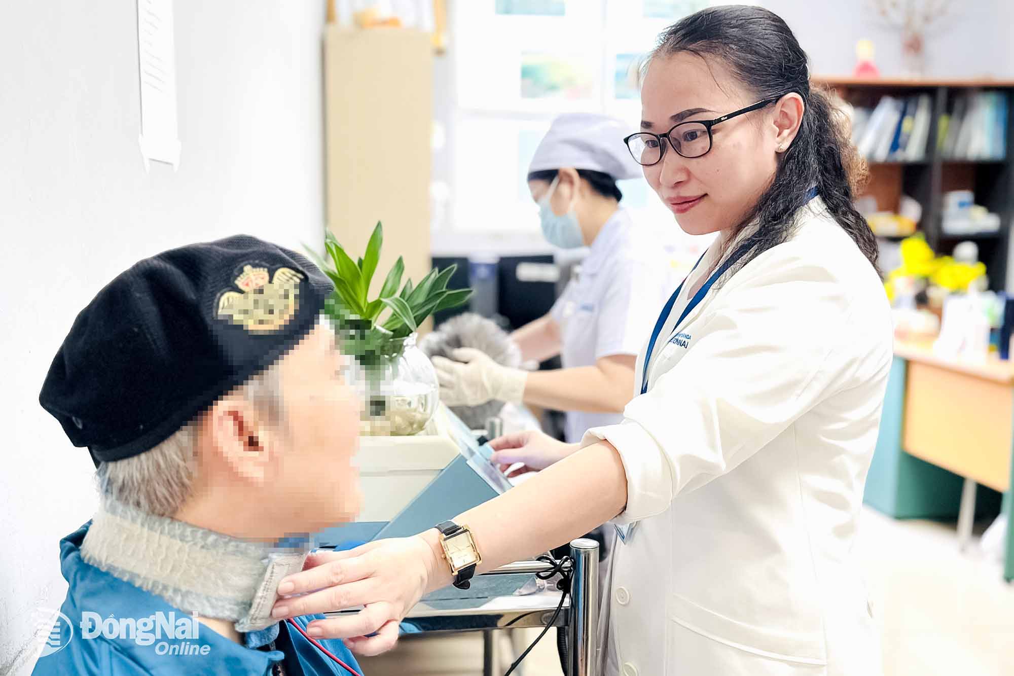 Thạc sĩ Nguyễn Như Giao, Trưởng khoa Phục hồi chức năng, Bệnh viện Đa khoa Đồng Nai, sử dụng máy để kích thích cơ vùng hầu họng cho bệnh nhân. Ảnh: Hạnh Dung