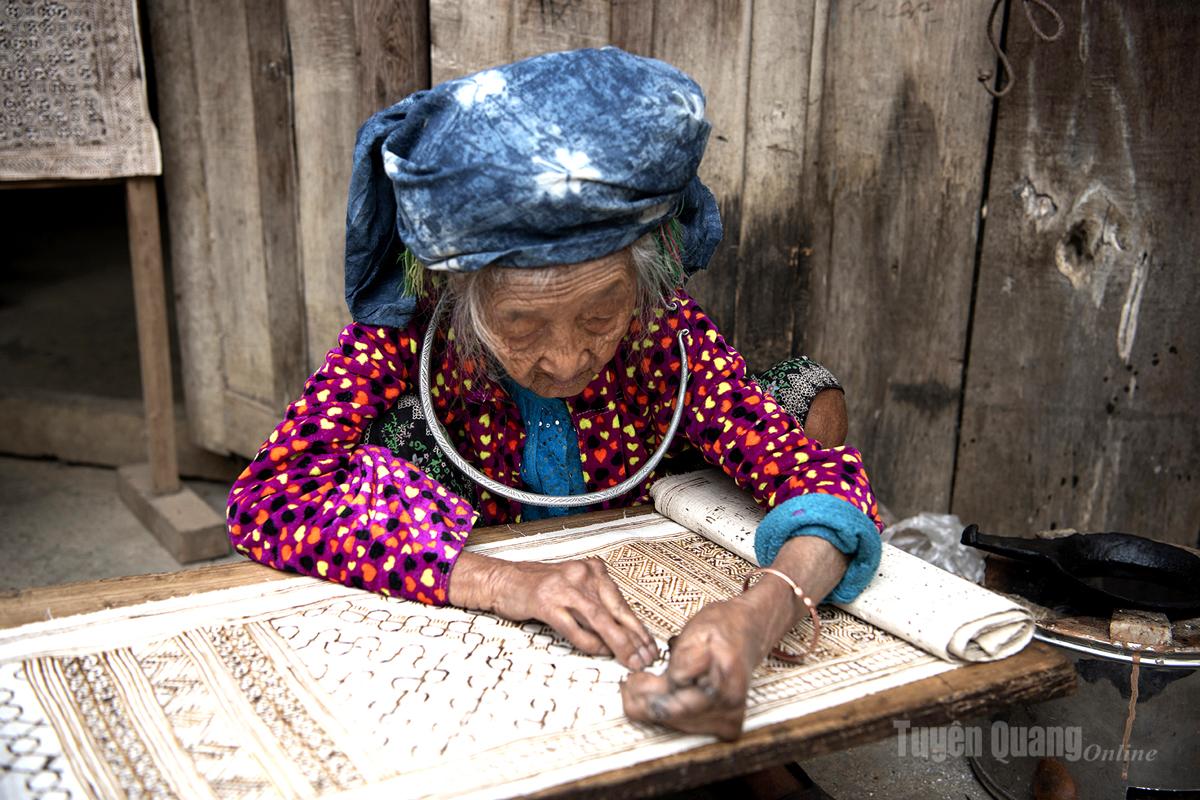 Hmong-Kunsthandwerker tragen sorgfältig Bienenwachs auf Leinenstoffe auf und schaffen so traditionelle Muster, die für die ethnische Gruppe der Hmong charakteristisch sind.