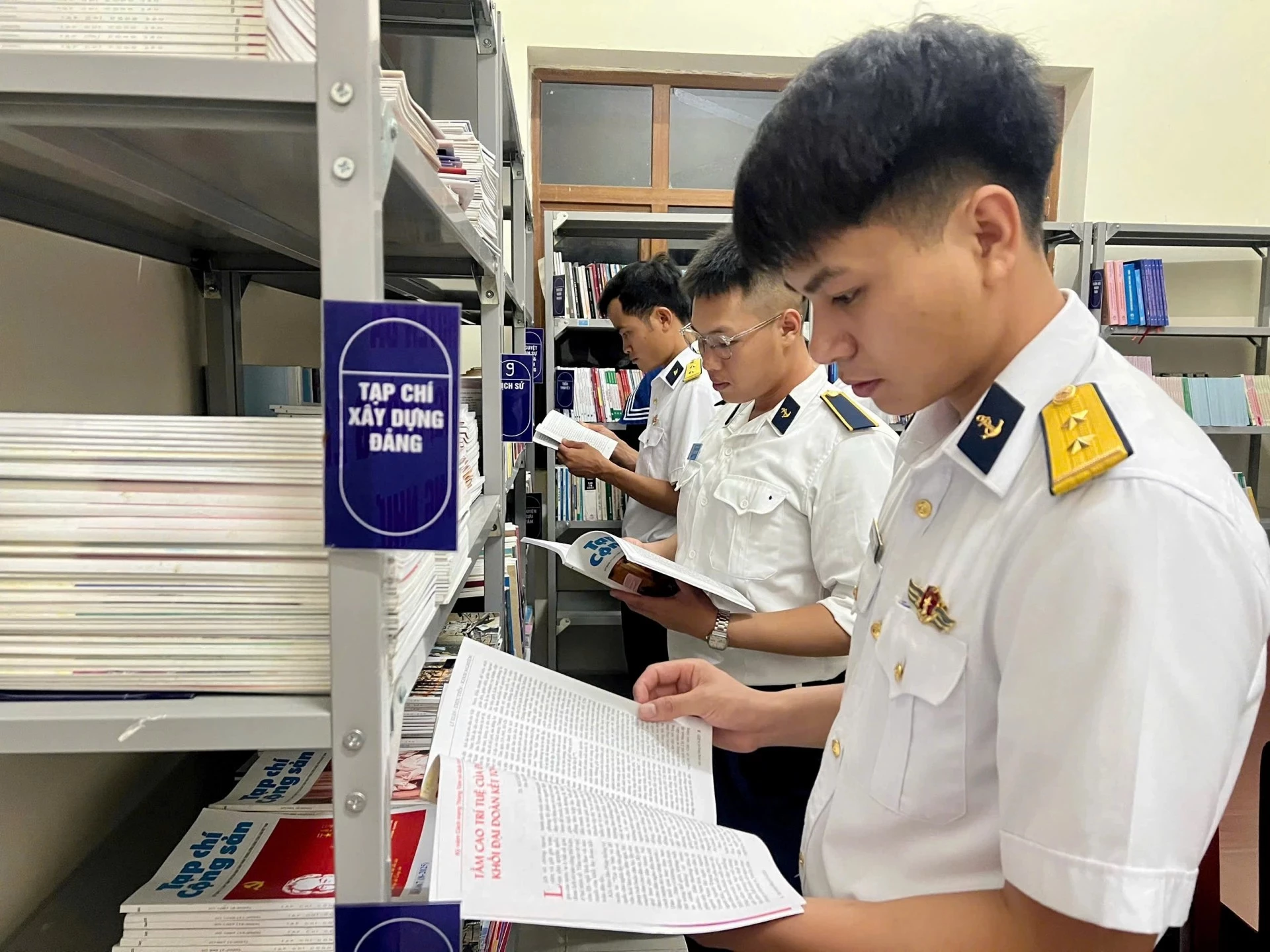 Officers and soldiers read books at the library of Brigade 682.