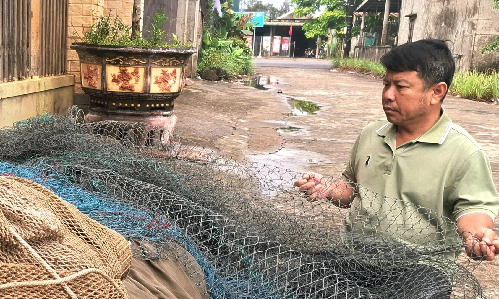 អ្នកនេសាទ ប៊ូយ ឌិញហ៊ុង នៅភូមិហាឡុក ឃុំកួវៀត កំពុងរៀបចំសំណាញ់របស់គាត់សម្រាប់ដំណើរនេសាទលើកក្រោយ - រូបថត៖ S.H