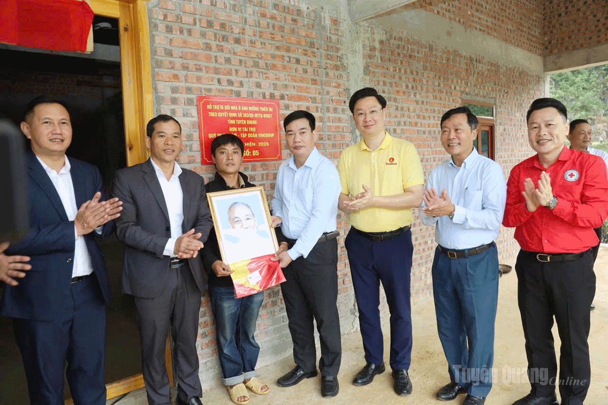Lãnh đạo Ủy ban MTTQ Việt Nam tỉnh và các đại biểu tặng Cờ Tổ quốc và ảnh Bác Hồ cho hộ dân.