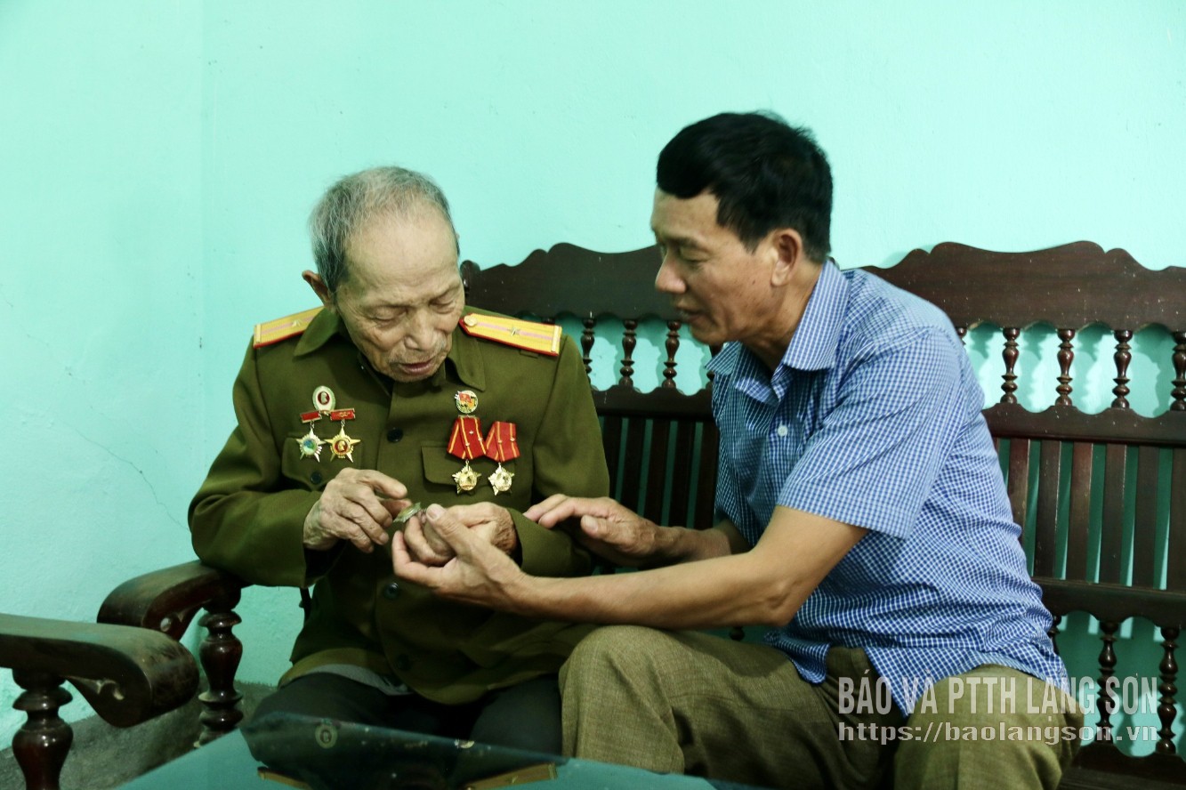 Veteran Ngo Gia Thanh (on the left) reminisces about revolutionary memories.
