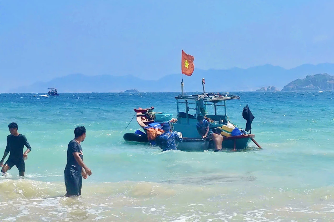 Cán bộ, chiến sĩ Tiểu đoàn 458 hỗ trợ ngư dân kéo, khắc phục sự cố ghe cá.