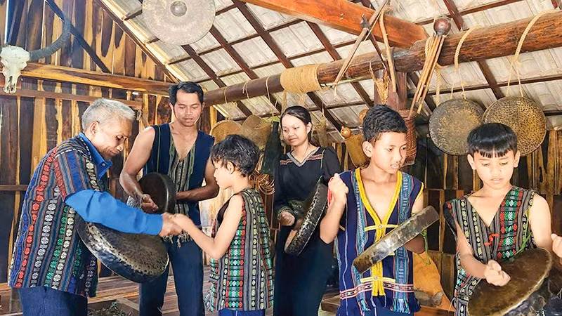 Les anciens du village enseignent à la jeune génération comment jouer des gongs et des tambours au village touristique de Co Ho Cil, dans le quartier de Cam Ly, à Da Lat.