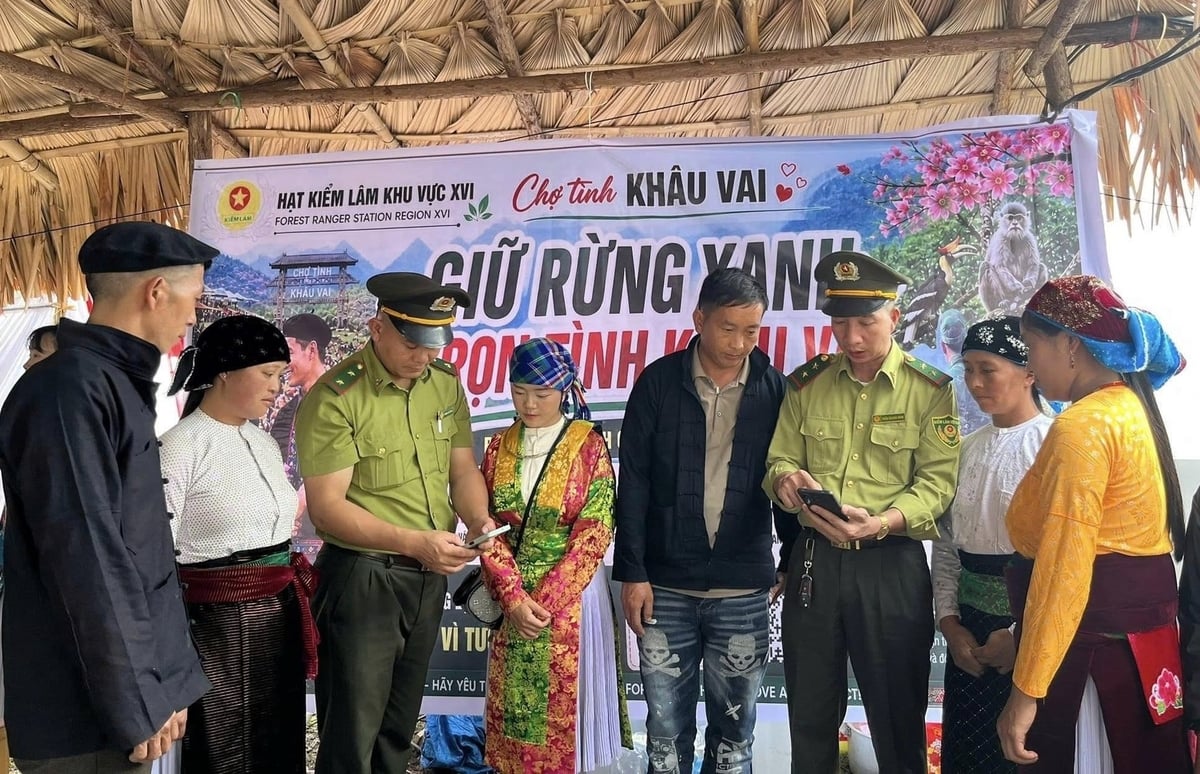 Cán bộ Hạt Kiểm lâm khu vực XVI tuyên truyền nâng cao kiến thức pháp luật về rừng và phòng cháy chữa cháy rừng cho người dân tại chợ tình Khâu Vai. Ảnh: Duy Tuấn.
