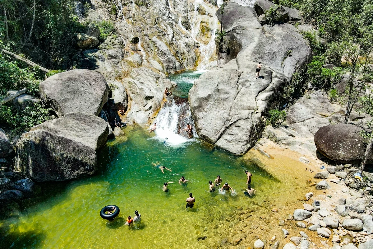 Au cœur de l'immense forêt, les touristes affluent vers la cascade de Ma Hao pour se rafraîchir.