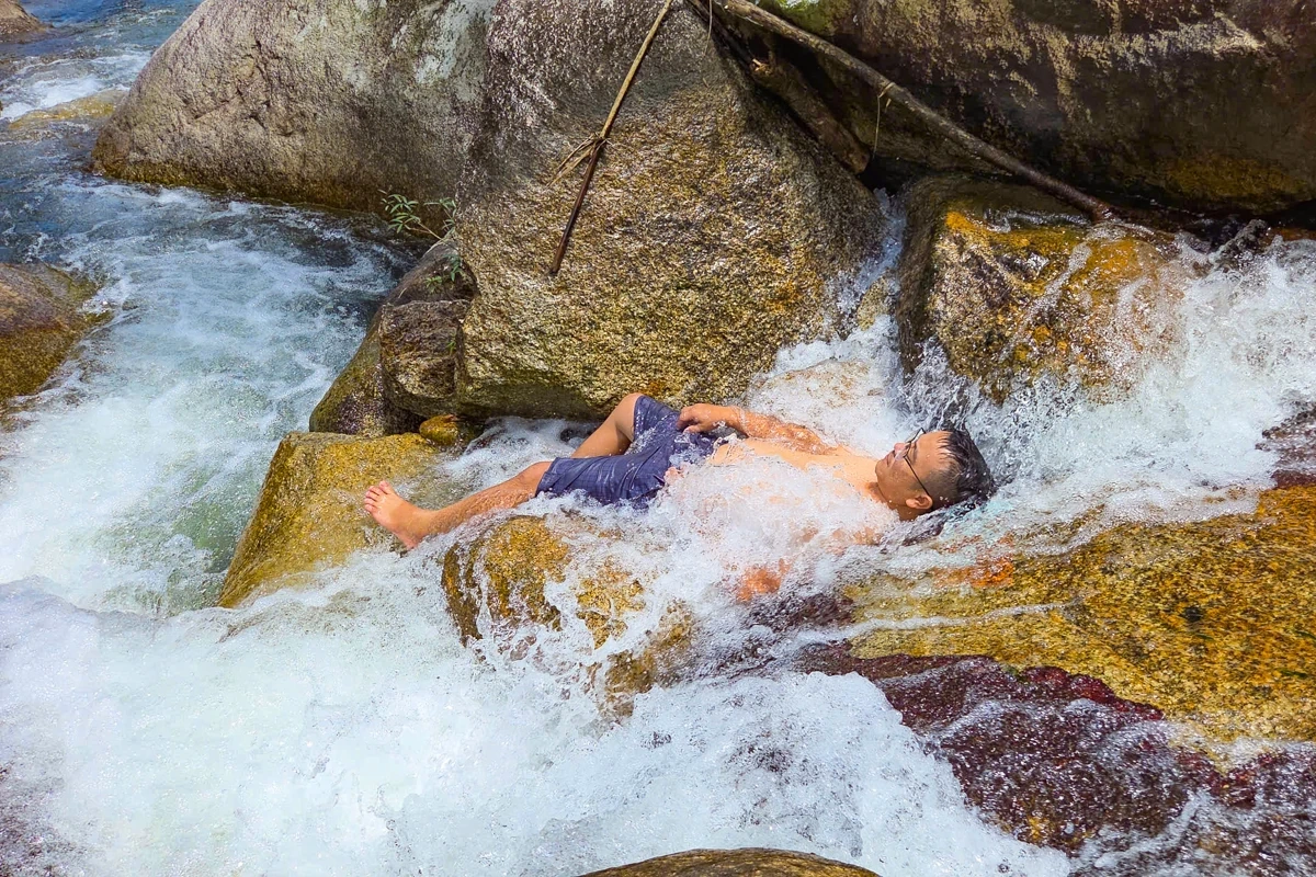 Au cœur de l'immense forêt, les touristes affluent vers la cascade de Ma Hao pour se rafraîchir.