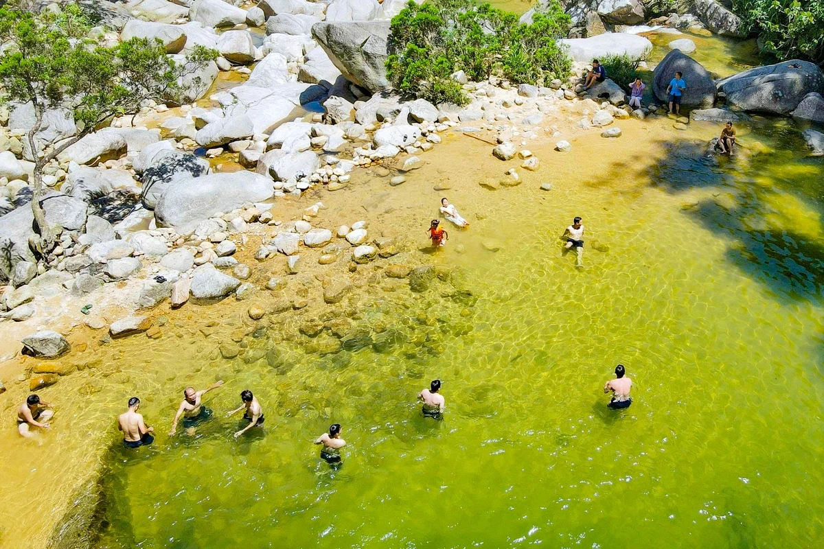 Au cœur de l'immense forêt, les touristes affluent vers la cascade de Ma Hao pour se rafraîchir.