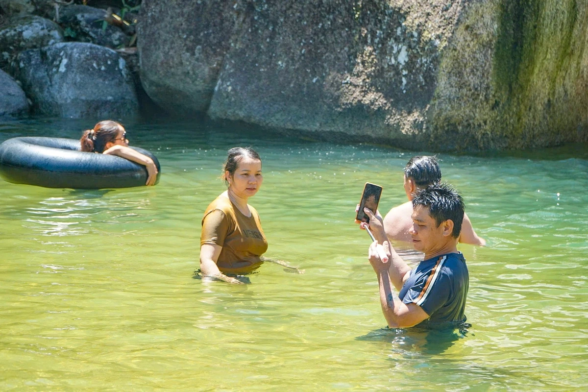 Au cœur de l'immense forêt, les touristes affluent vers la cascade de Ma Hao pour se rafraîchir.