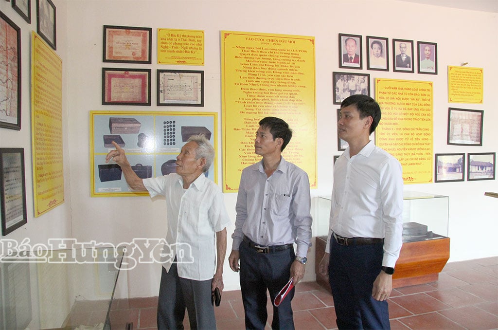 Veterán Pham Van Cu z vesnice Vi Giang v obci Hong Minh (první zleva) spolu s úředníky obce prohlíží válečné dokumenty na historickém místě revoluce Truong Vi Si.