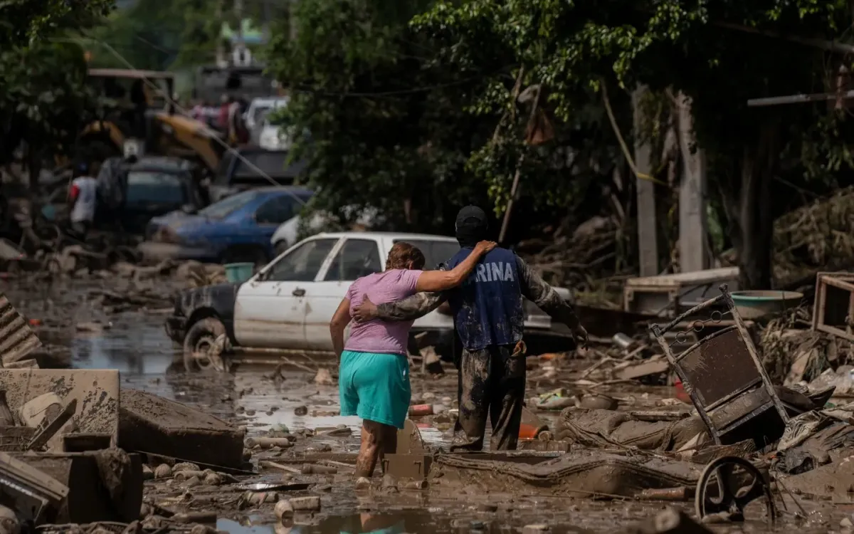 Một sĩ quan hải quân hỗ trợ người dân đi qua tuyến phố ngập sau mưa lớn tại Veracruz, Mexico, ngày 12/10/2025. (Ảnh: AP)