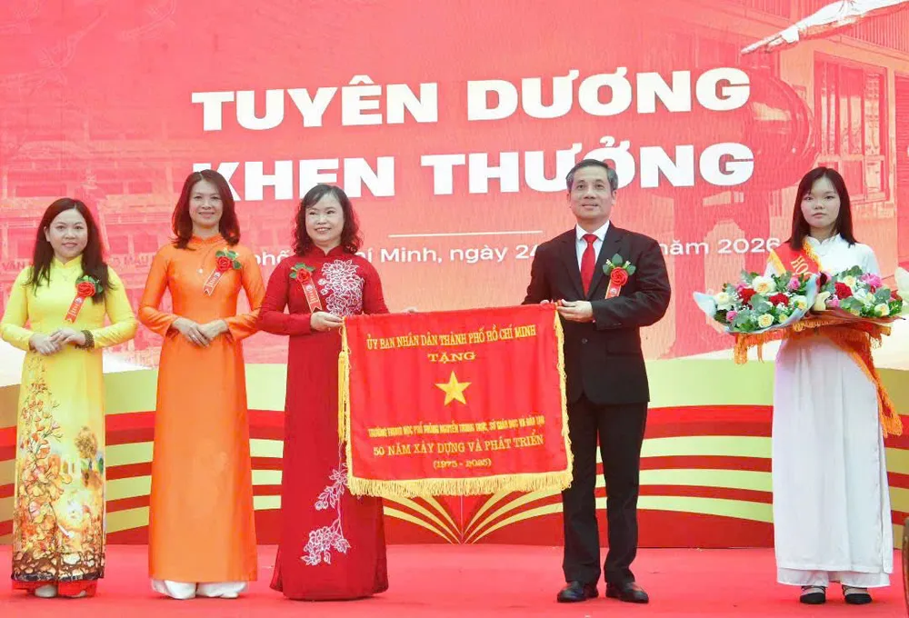 Ông Nguyễn Kế Toại, Phó Giám đốc Sở GD-ĐT TPHCM, trao cờ thi đua của UBND TPHCM tặng Trường THPT Nguyễn Trung Trực