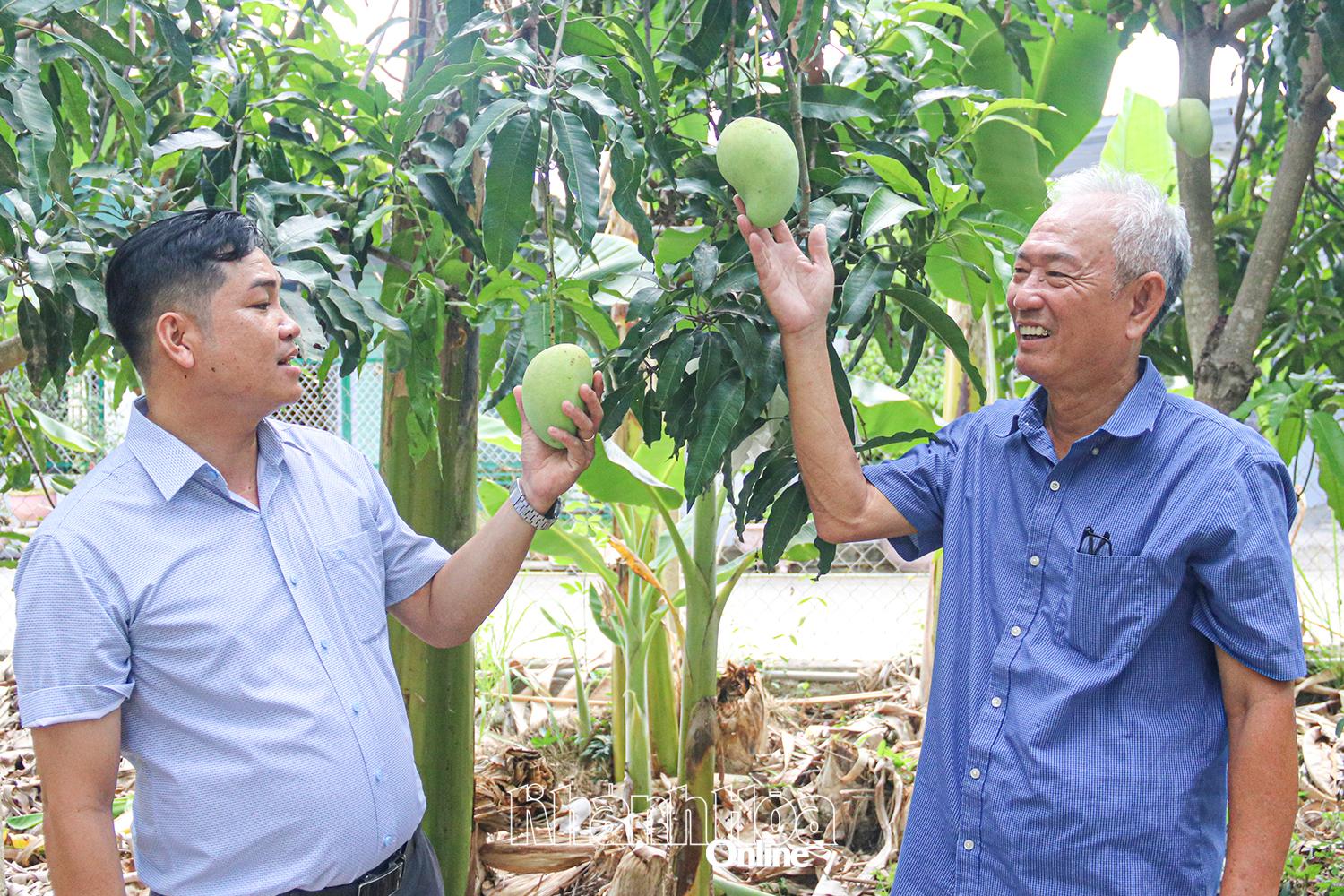Ông Nguyễn Thọ (bên phải) chia sẻ về mô hình vườn cây ăn quả của gia đình.