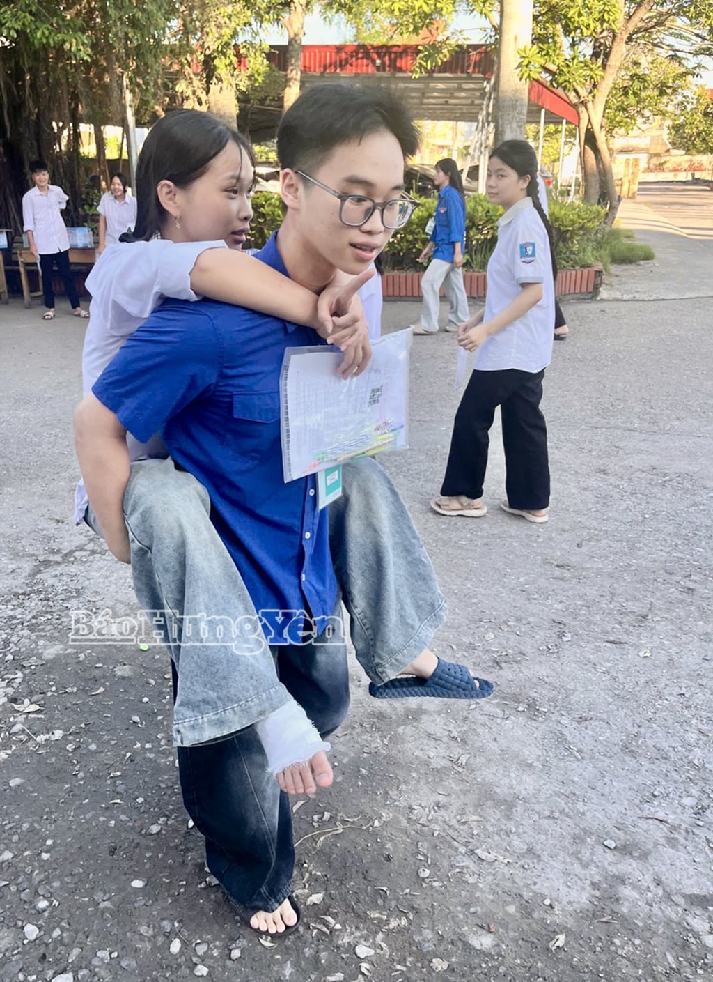 Unga volontärer från Hung Ha kommun bar en elev med en benskada till provplatsen på Bac Duyen Ha High School.