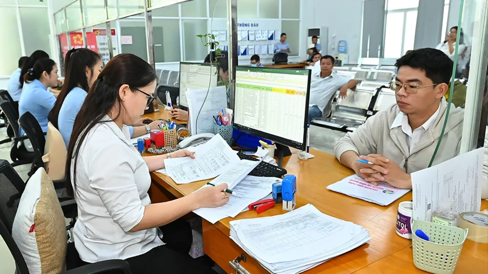 I funzionari del Centro di servizi amministrativi pubblici del distretto di Dĩ An si occupano delle procedure amministrative per i cittadini. Foto: VIET DUNG