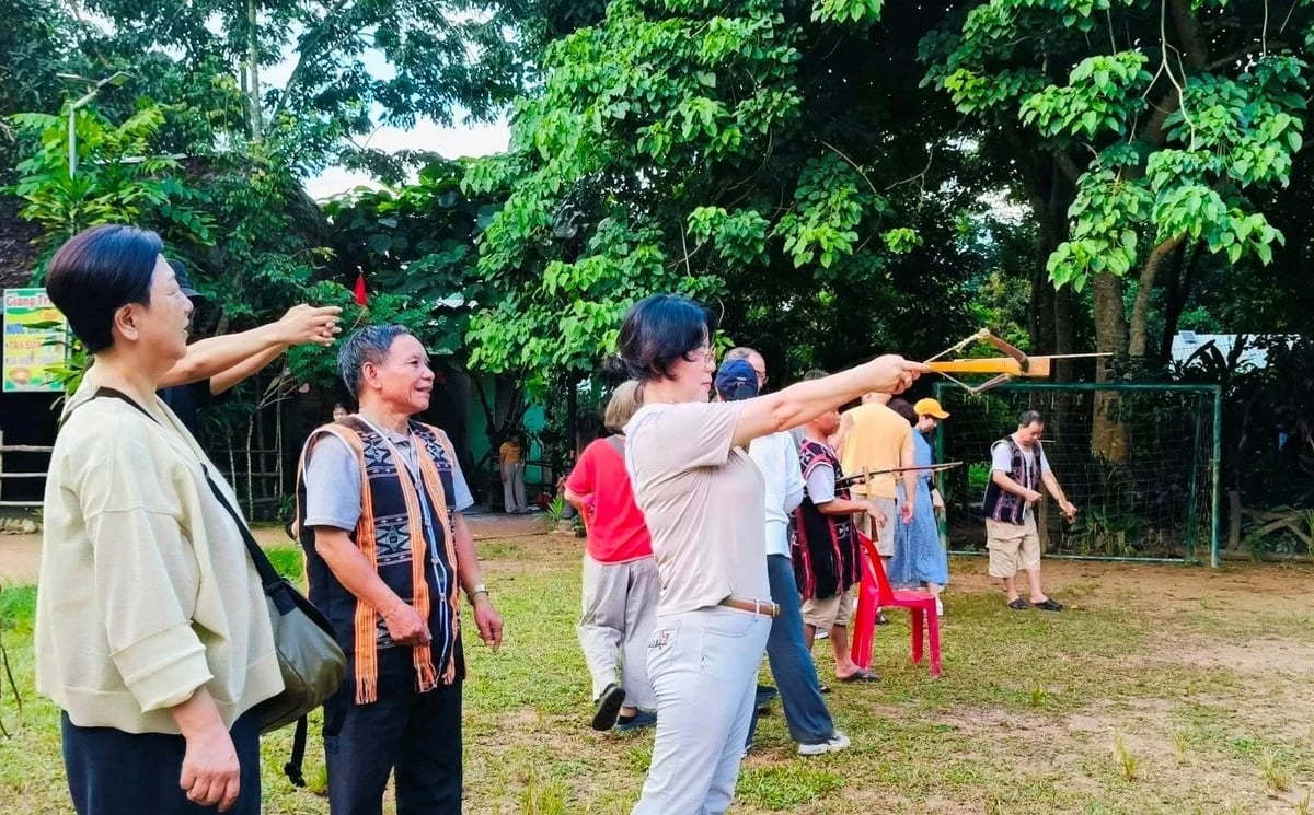 นักท่องเที่ยวเรียนรู้วิธีการยิงหน้าไม้ขณะเยี่ยมชม Bhơ Hôồng ภาพ: Lan Anh Du khách học cách bắn nỏ khi đến với Bhơ Hôồng. Ảnh: Lan Anh.