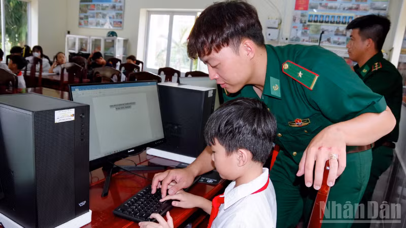 Cán bộ đồn Biên phòng Vĩnh Hải trực tiếp hướng dẫn các em thực hành trên máy tính.