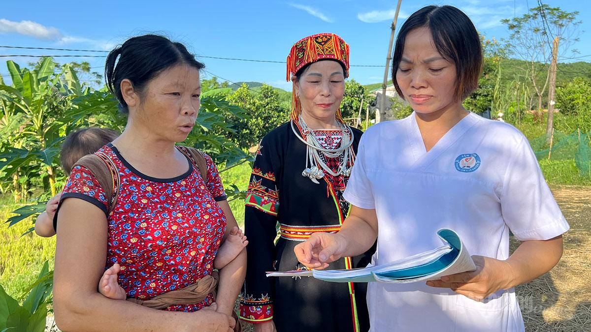 Petugas kesihatan di balai kesihatan komune Yen Son sedang menyebarkan maklumat tentang cara mencegah penularan HIV daripada ibu kepada anak kepada setiap isi rumah.